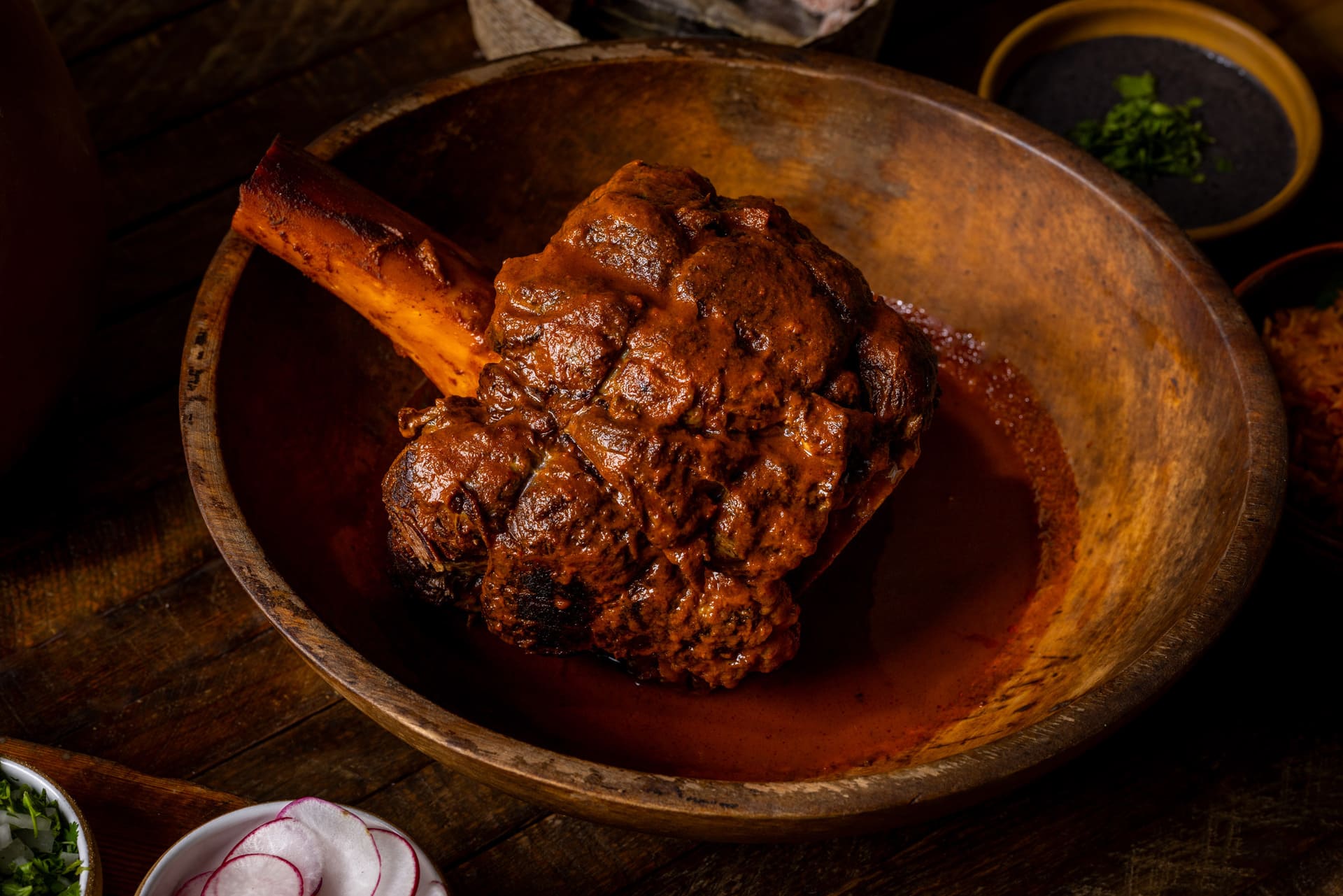 Delicious Bone in Steak with flavorful sauce and garnishes from MXO Steakhouse.